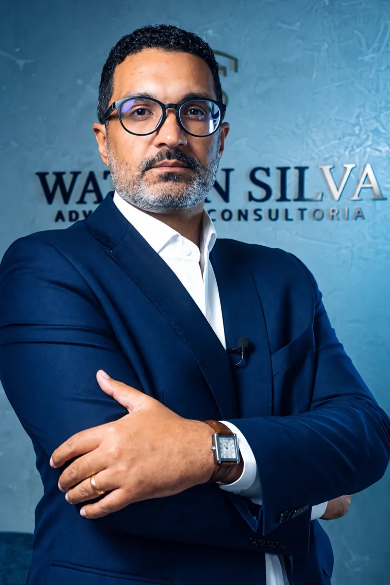Watson Silva, advogado empresarial, de braços cruzados em frente ao letreiro do escritório